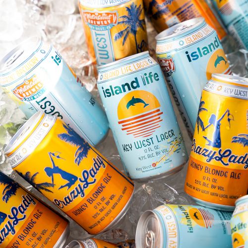 A collection of colorful beverage cans labeled "Island Life" and "Lazy Ladi" resting on ice.